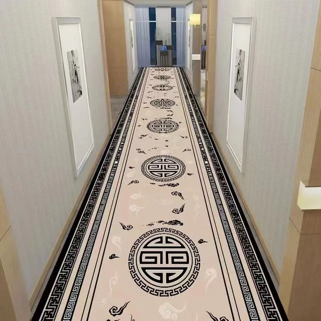 Tapis de couloir haut de gamme Ce tapis de couloir haute gamme présente un fond beige orné de motifs orientaux noirs. Trois grands médaillons circulaires, entourés de petits motifs décoratifs, sont alignés au centre. Les bordures, avec leurs motifs géométriques noirs, encadrent élégamment le tapis, créant un contraste sophistiqué. Parfait pour ajouter une touche de luxe et de style à votre couloir tout en offrant une protection durable pour vos sols.